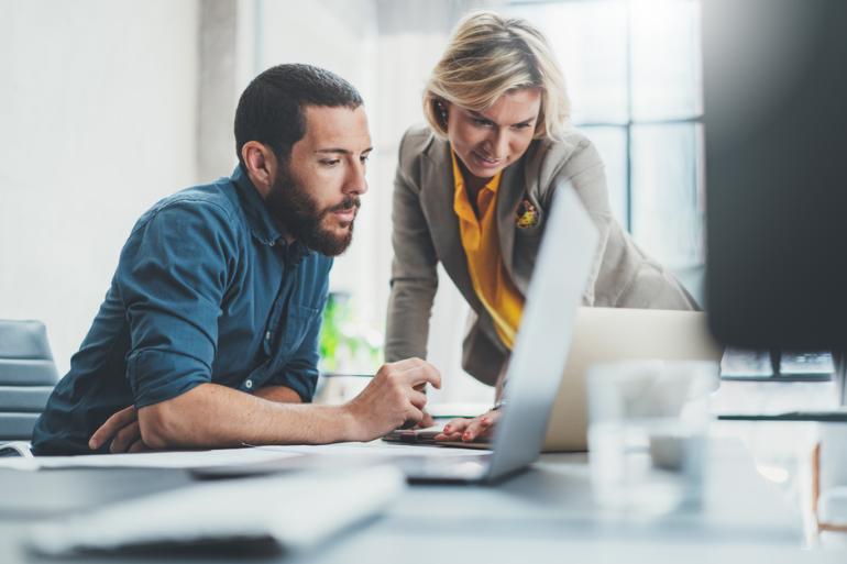 Hombre y mujer trabajando frente a un computador